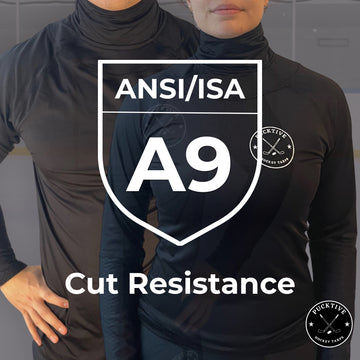 Two people wearing black shirts with ANSI/ISA A9 cut resistance label.
