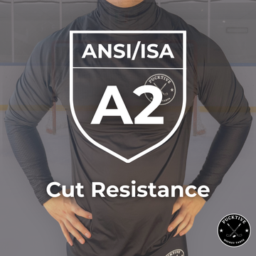 Person wearing a black long-sleeve shirt with ANSI/ISA A2 cut resistance certification on a gray background.