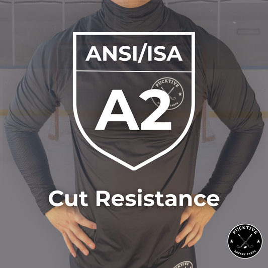Person wearing a black long-sleeve shirt with ANSI/ISA A2 cut resistance certification on a gray background.