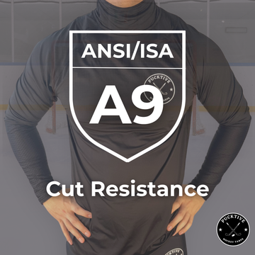 Person wearing a black long-sleeve shirt with ANSI/ISA A9 cut resistance certification on a gray background.